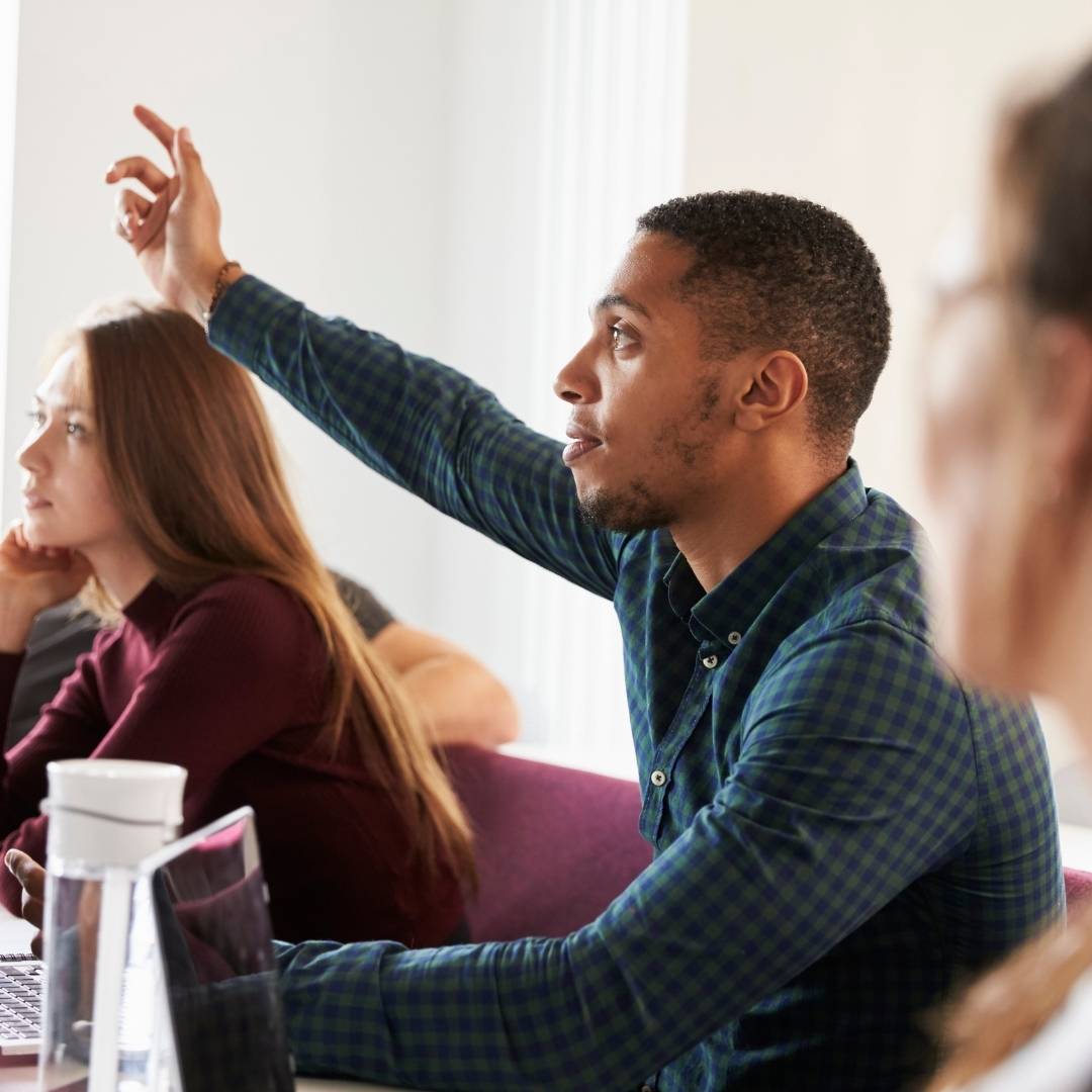 13 Samples of questions to ask when starting a new job, a man rasing his hand at a meeting